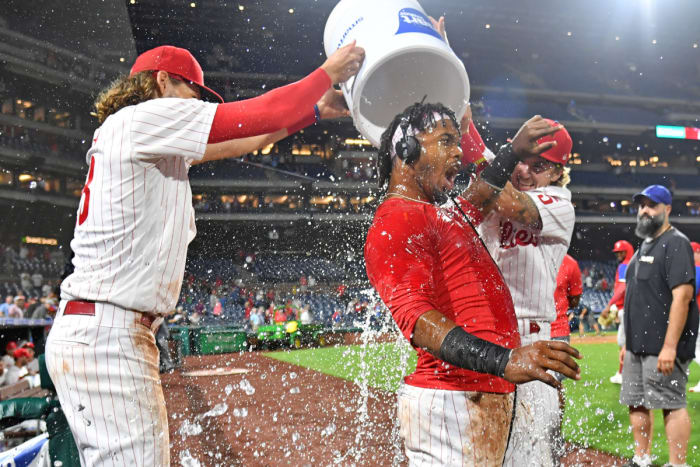 Alec Bohm and Bryson Stott help Jean Segura celebrate a walk-off single.